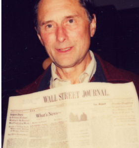 Alfred Peet showing the front page of the Wall Street Journal