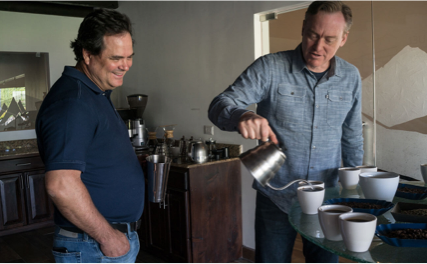 Doug Welsh pouring cups of coffee with a colleague